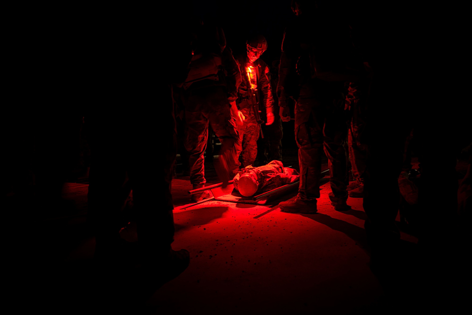 in the dark, Airmen practice paramedic work in the glow of their red headlamps