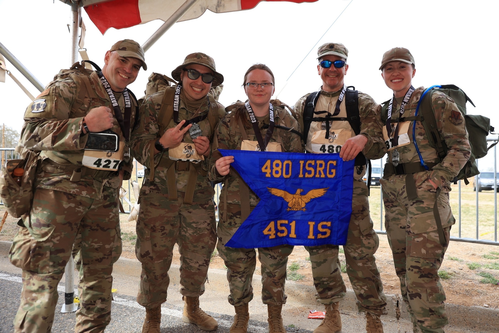 Current and former members of the 451st Intelligence Squadron, at the Bataan Memorial Death March Finish Liner, after finishing a grueling 26-mile ruck march, competing in the co-ed heavy division, White Sands Missile Range, New Mexico.