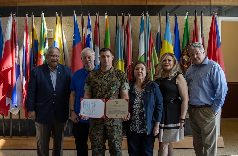 Staff Sgt. Derek Ferrari, a Detachment Commander, stands alongside his family and the Secretary of the Navy, the Honorable Mr. Carlos Del Toro, after receiving the Navy and Marine Corps Commendation Medal at Marine Corps Embassy Security Group Headquarters in Quantico, Va., May 19, 2023. Del Toro awarded the 12 Marine Security Guards with Detachment Khartoum for their efforts in safely evacuating 75 embassy personnel from the U.S. Embassy in Khartoum amid surging conflict in Sudan. (U.S. Marine Corps photo by Sgt. Braden Hale)