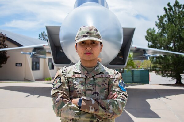 Airman 1st Class Dianne Rivera stands in front of a model Air Craft at Peterson Space Force Base.