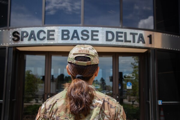 Airman 1st Class Rivera stands in front of Space Base Delta 1's Headquarters. Rivera works in finance, helping to keep SBD1 on budget and it's Airmen paid.