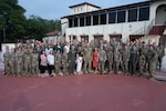Group photo of newly assigned command team and spouse standing outside of the Parr Club at Joint Base San Antonio-Randolph.