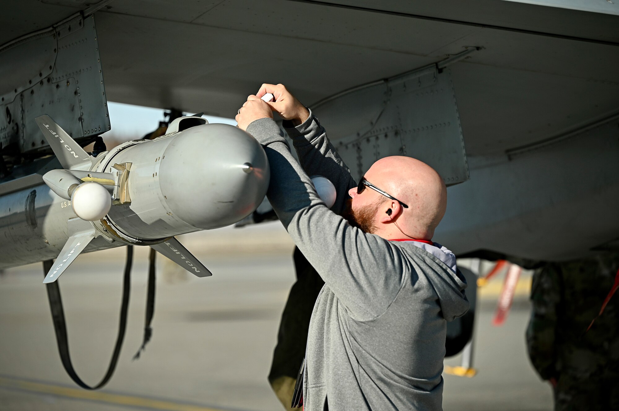 Chris Culver, an electronic warfare engineer with the Air National Guard Air Force Reserve Command Test Center, tightens a panel on the “angry kitten” combat pod, an electronic warfare countermeasure system housed under the wing of an F-16 Fighting Falcon, at Eielson Air Force Base, Alaska, May 5, 2023, during Northern Edge 2023.