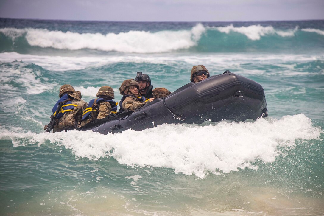 Soldiers ride in a small boat in a body of water.
