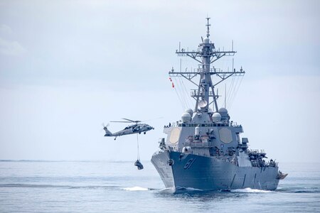 An MH-60S Sea Hawk helicopter assigned to the "Tridents" of Helicopter Sea Combat Squadron 9 (HSC 9) conducts a vertical replenishment with the Arleigh Burke-class guided-missile destroyer USS Ramage (DDG 61).