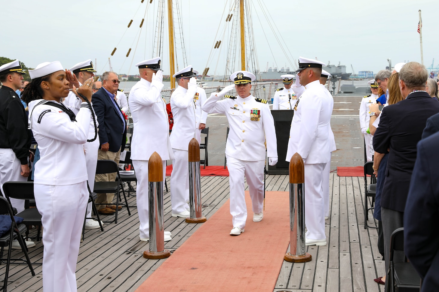 Cmdr. Chris Turner renders a salute to sideboys during a change of command ceremony for the Virginia-class attack submarine USS John Warner (SSN 785) aboard the decommissioned Iowa-class battleship USS Wisconsin.