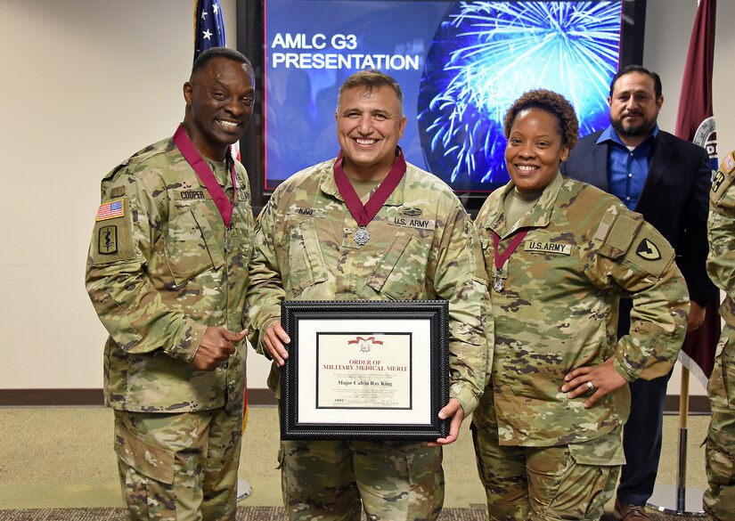 Maj. Calvin King, center, is pictured with Col. Gary Cooper, commander of U.S. Army Medical Logistics Command, and Master Sgt. Danielle Smith after being inducted into the Order of Military Medical Merit during an AMLC awards ceremony May 16, 2023, at Fort Detrick, Maryland.