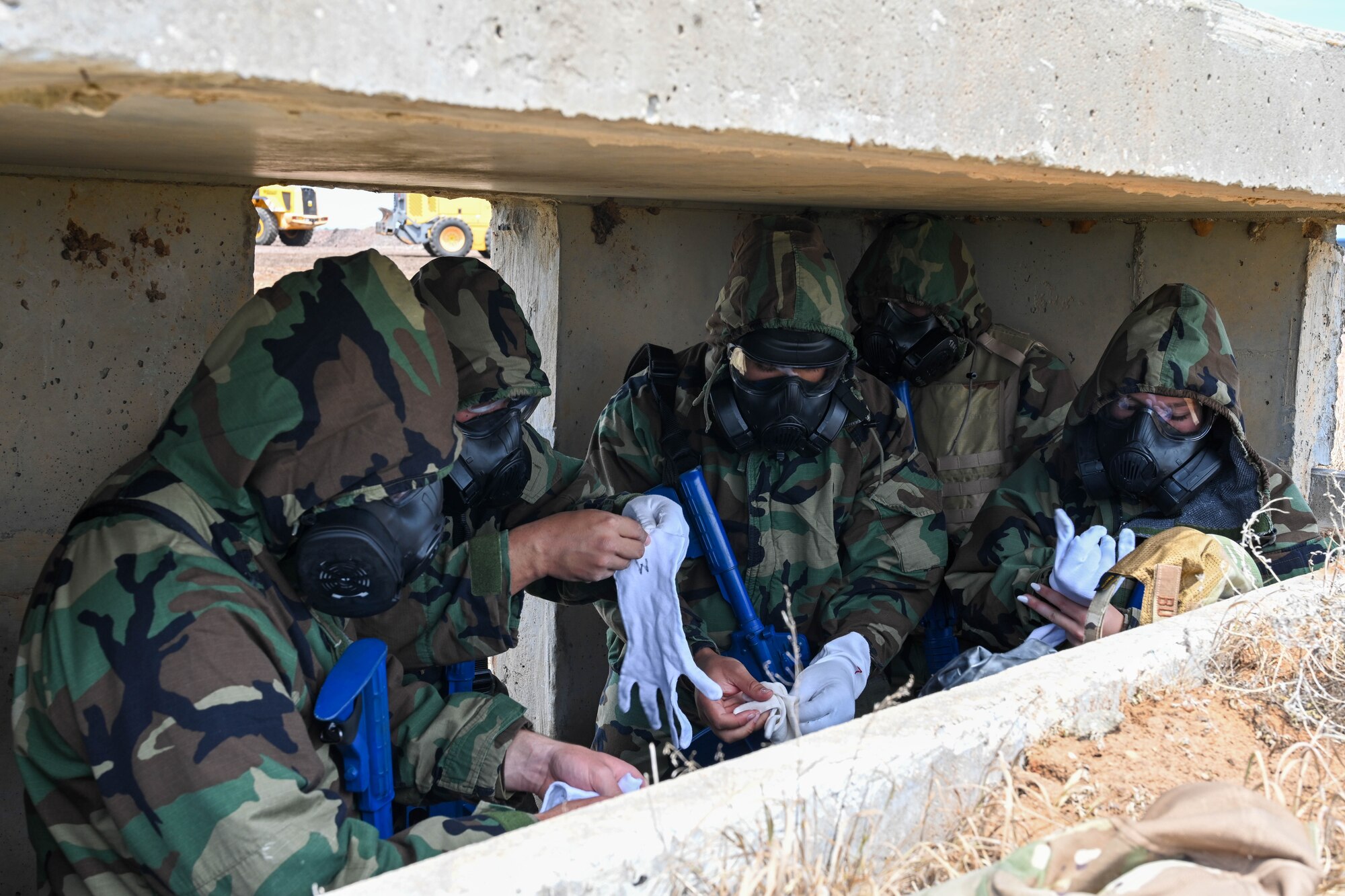 Airmen from the 97th Air Mobility Wing don Mission Oriented Protective Posture (MOPP) gear during an exercise at Altus Air Force Base, Oklahoma, May 2, 2023. MOPP gear is often used during a Chemical Biological Radiological Nuclear hazard. (U.S. Air Force photo by Senior Airman Trenton Jancze)