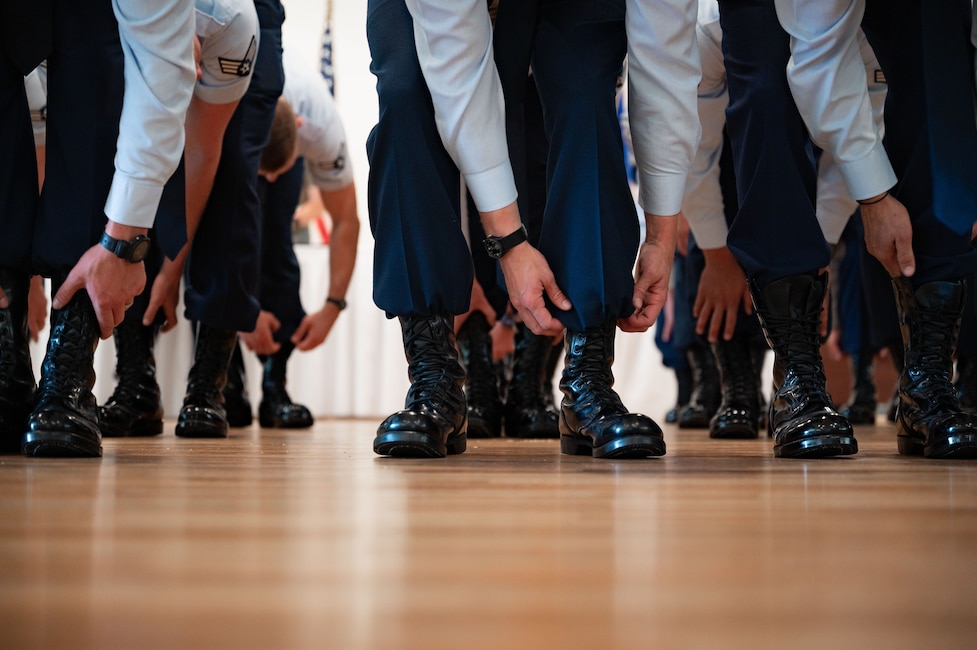 boots in a row, their owners blousing them for the first time