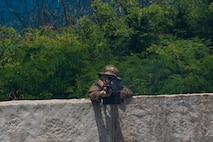A U.S. Army infantryman with Bravo Company, 2nd Battalion, 35th Infantry Regiment, 3rd Infantry Brigade Combat Team, 25th Infantry Division, provides suppressive fire during Military Operations in Urbanized Terrain training at Pyramid Rock Beach, Marine Corps Base Hawaii, May 16, 2023. The purpose of the exercise was to train to secure a beach landing site in order to insert a raid force to ensure the units are ready to conduct a full spectrum of waterborne operations. (U.S. Marine Corps photo by Lance Cpl. Terry Stennett III)