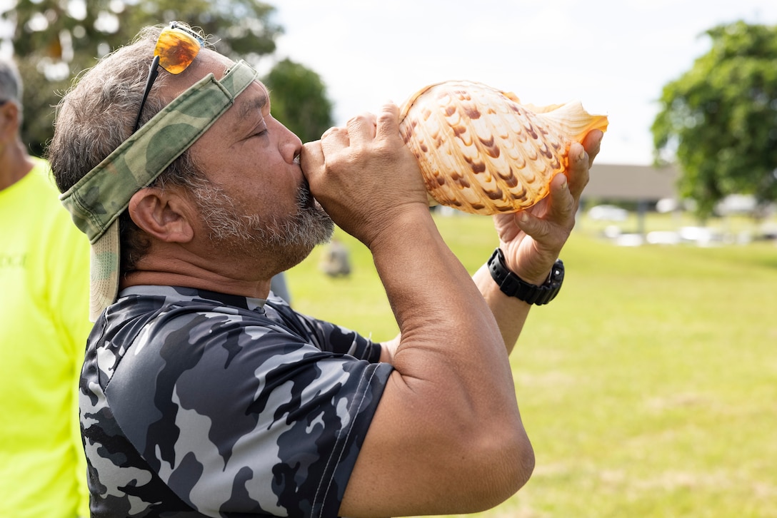 A member of the local community blows into a pu to initiate the Marine Corps Base Hawaii and Paepae o He’eia Nu’upia Ponds Wildlife Management Area Co-Stewardship Event Signing, May 15, 2023. The memorandum of understanding establishes an understanding for the maintenance of cultural resources and collaborative support to the biodiversity of natural resources within the Nu’upia Ponds Wildlife Management Area, while encouraging opportunities to collaborate on stewardship pertaining to the Nu’upia Ponds aboard the installation. (U.S. Marine Corps photo by Cpl. Samantha Sanchez)