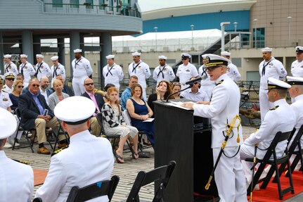 Cmdr. Ryan Heineman delivers remarks during a change of command ceremony for the Virginia-class attack submarine USS John Warner (SSN 785) aboard the decommissioned Iowa-class battleship USS Wisconsin.
