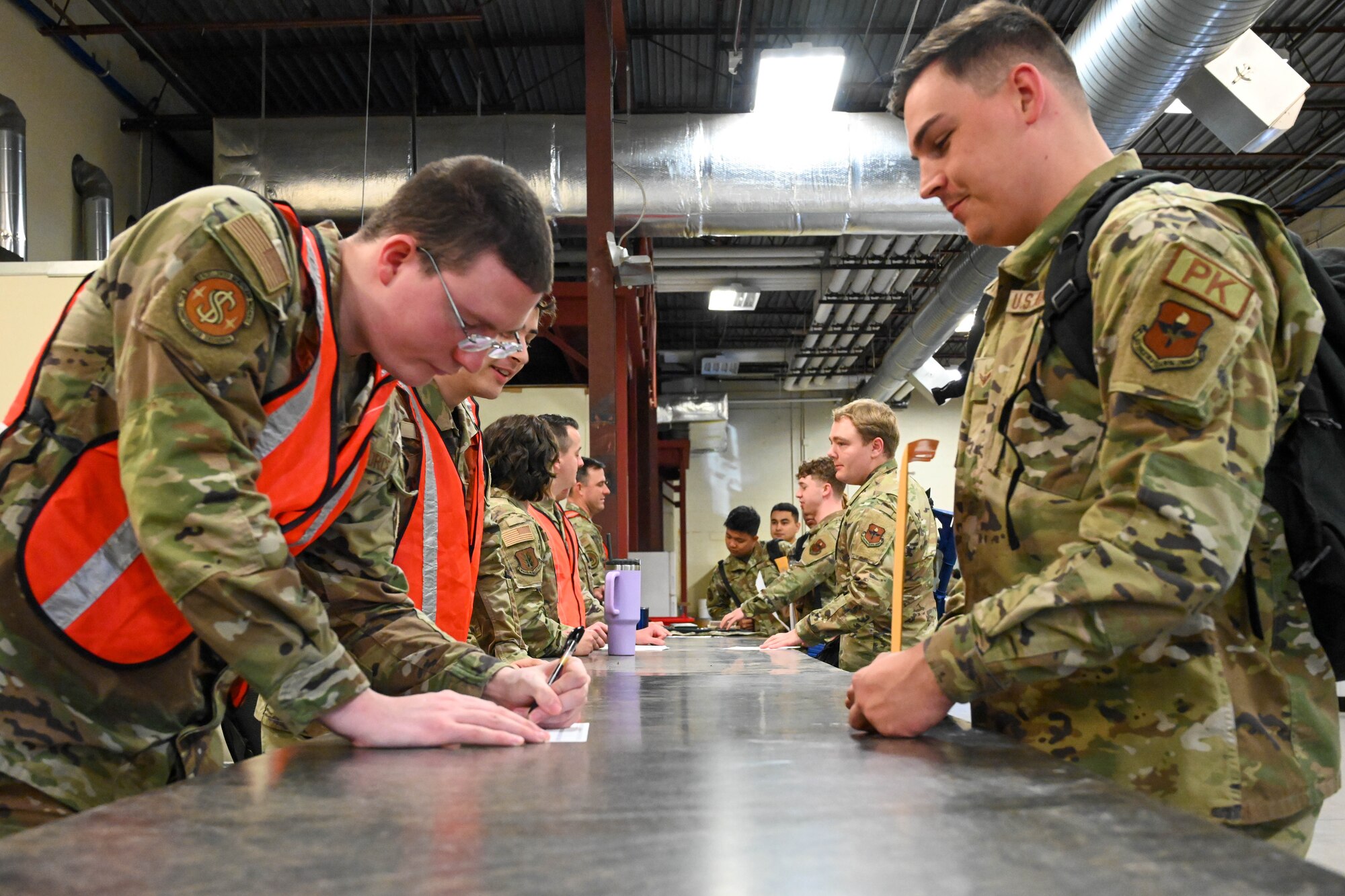 Airmen from the 97th Air Mobility Wing go through a mock deployment line during an exercise at Altus Air Force Base, Oklahoma, May 2, 2023. Exercises of this nature are critical for evaluating the wing’s readiness. (U.S. Air Force photo by Senior Airman Trenton Jancze)