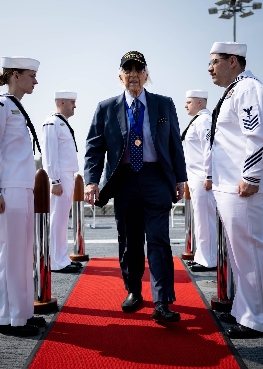 Mr. Dave Yoho, U.S. Merchant Marine and World War II Veteran, is piped aboard during a National Maritime Day ceremony aboard USNS Comfort (T-AH 20) May 22, 2023. National Maritime Day honors the thousands of dedicated merchant mariners who served aboard United States vessels around the world.