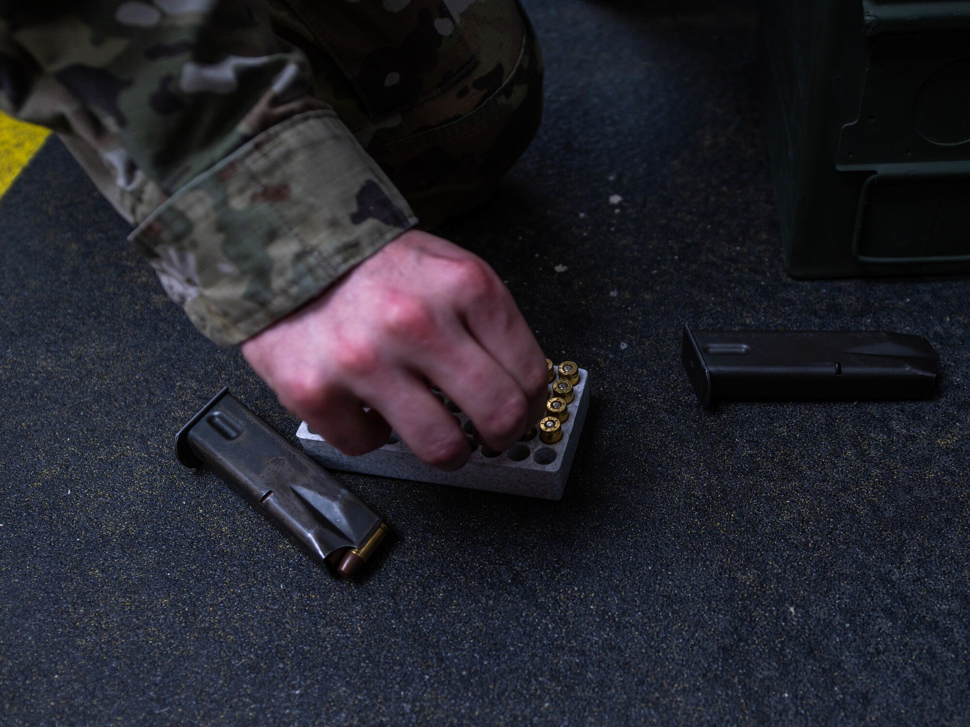 An Airman assigned to the 56th Security Forces Squadron selects a 9mm bullet to load into a magazine, May 17, 2023, at Luke Air Force Base, Arizona.