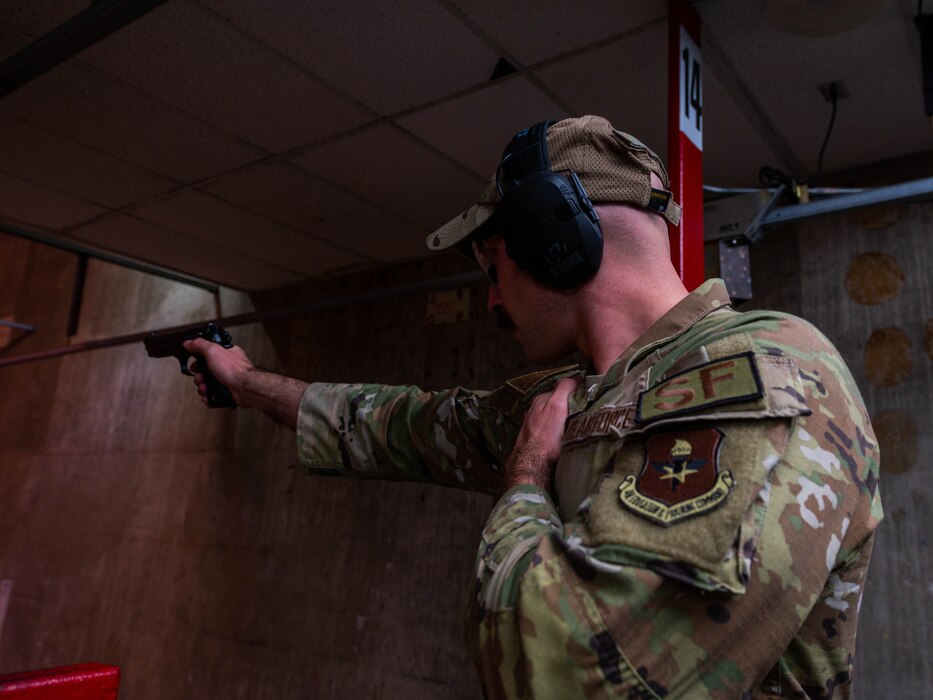 U.S. Air Force Staff Sgt. Alexander Klein, 56th Security Forces Squadron unit trainer, takes aim with a Baretta M9 handgun, May 17, 2023, at Luke Air Force Base, Arizona.