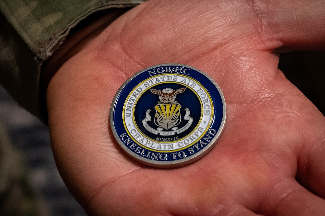 U.S. Air Force Senior Master Sgt. Stephen Agnelli, recruiting senior enlisted leader, National Guard Bureau Recruiting and Retention Division, holds a challenge coin from the Air National Guard (ANG) Chaplain Corps during the ANG Chaplain Corps Senior Religious Support Team Symposium in Arlington, Virginia, May 17, 2023.