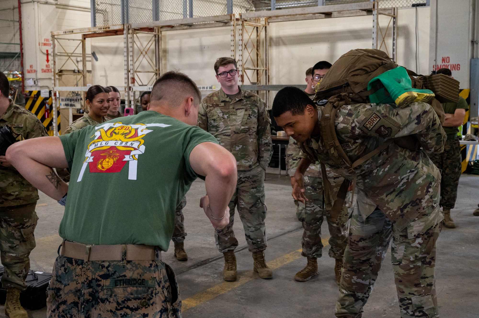 An Airman wears a Marine CBRN ruck sack.