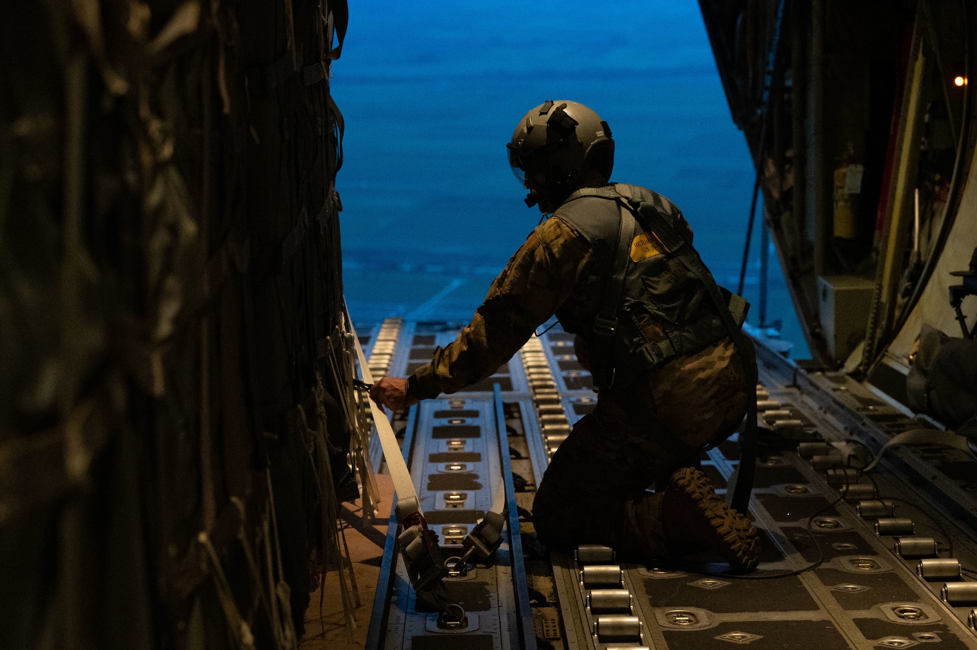 A person prepares to free cargo pallets for an airdrop delivery