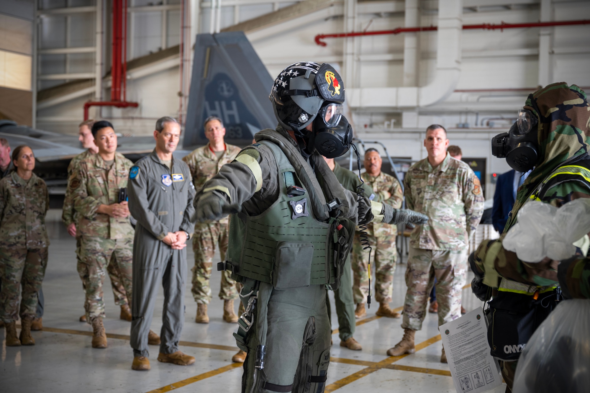 U.S. Air Force Capt. Alex “Doom” Moss, 19th Fighter Squadron F-22 Raptor pilot, utilizes the aircrew ensemble respiratory protection system while processing through the aircrew contamination control area during the Next Generation Aircrew Protection Step-Launch and Recover demonstration at Joint-Base Pearl Harbor-Hickam, Hawaii, May 11, 2023. The demonstration showcases the Pacific Air Forces stop gap for the F-22 Aircrew Chemical, Biological, Radiological and Nuclear limiting factor utilizing the modified M-50 ground crew mask. (U.S. Air National Guard photo by Master Sgt. Mysti Bicoy)
