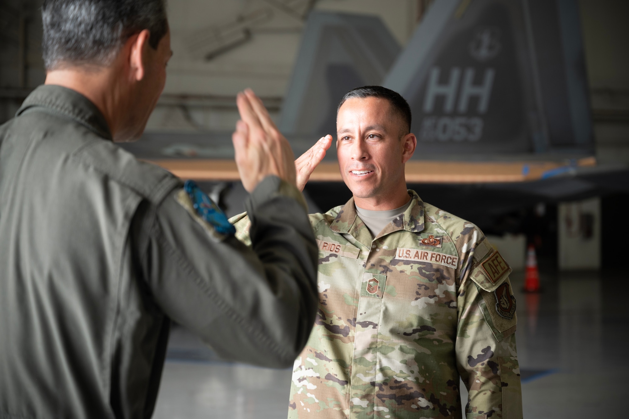 U.S. Air Force Senior Master Sgt. Ryan Rios, command aircrew flight equipment manager, salutes Gen. Ken Wilsbach, Pacific Air Forces commander, after receiving recognition for his outstanding performance during the Next Generation Aircrew Protection Step-Launch and Recover demonstration at Joint-Base Pearl Harbor-Hickam, Hawaii, May 11, 2023. Rios’ team demonstrated the PACAF stop gap for the F-22 Aircrew CBRN limiting factor utilizing the modified M-50 ground crew mask. They also demonstrated how these operationally relevant capabilities provide Gen. Wilsbach with commander’s decision superiority to generate combat sorties safely in a Chemical environment while maximizing aircrew performance. (U.S. Air National Guard photo by Master Sgt. Mysti Bicoy)