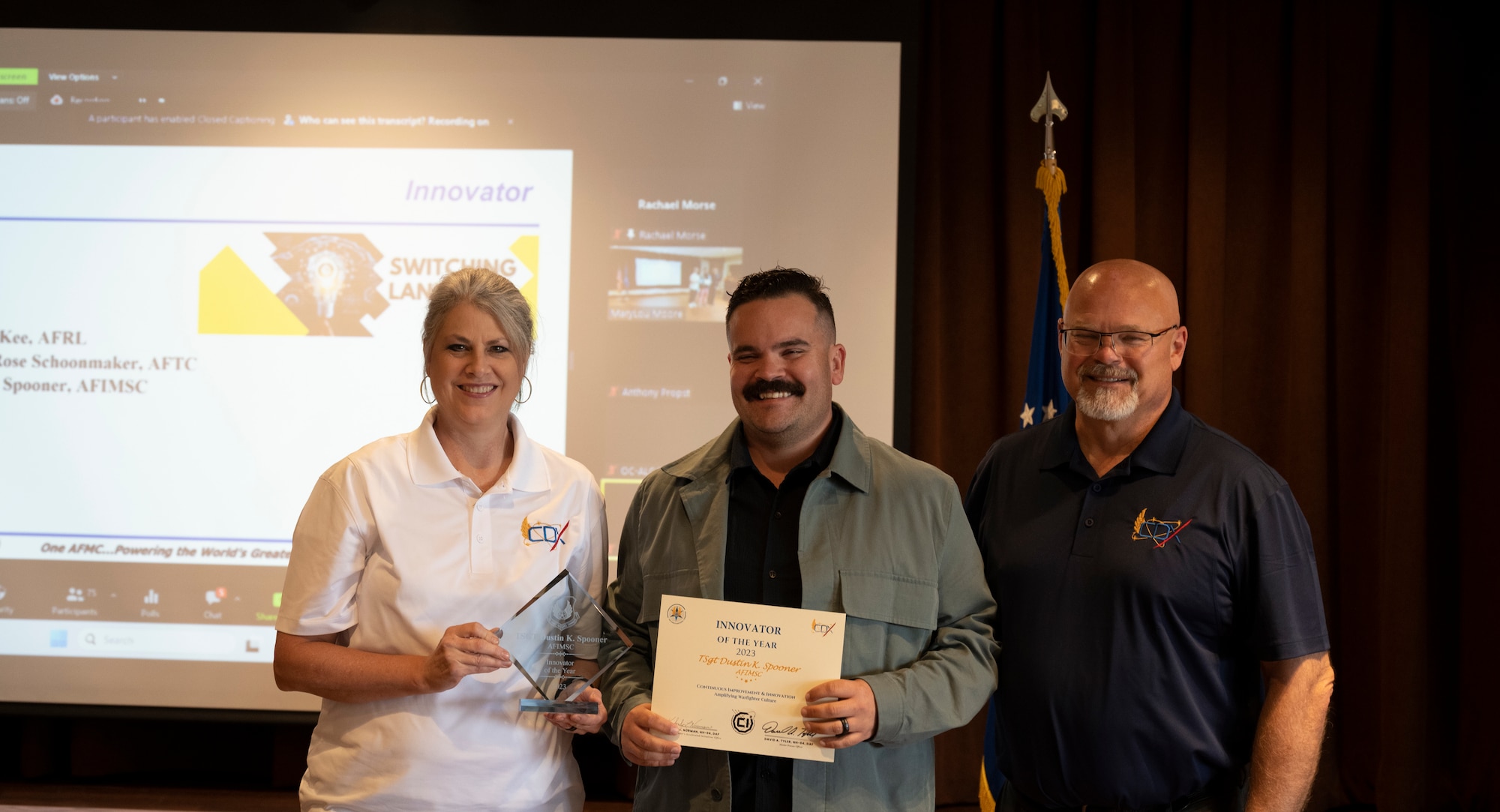 Tech. Sgt. Dustin Spooner, takes a picture with CDX team members to celebrate his award.