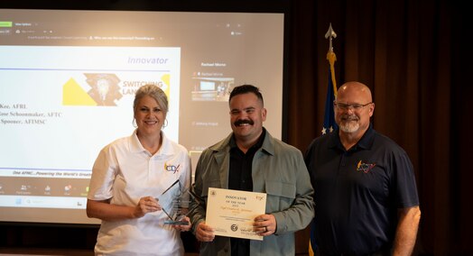  Tech. Sgt. Dustin Spooner, takes a picture with CDX team members to celebrate his award.