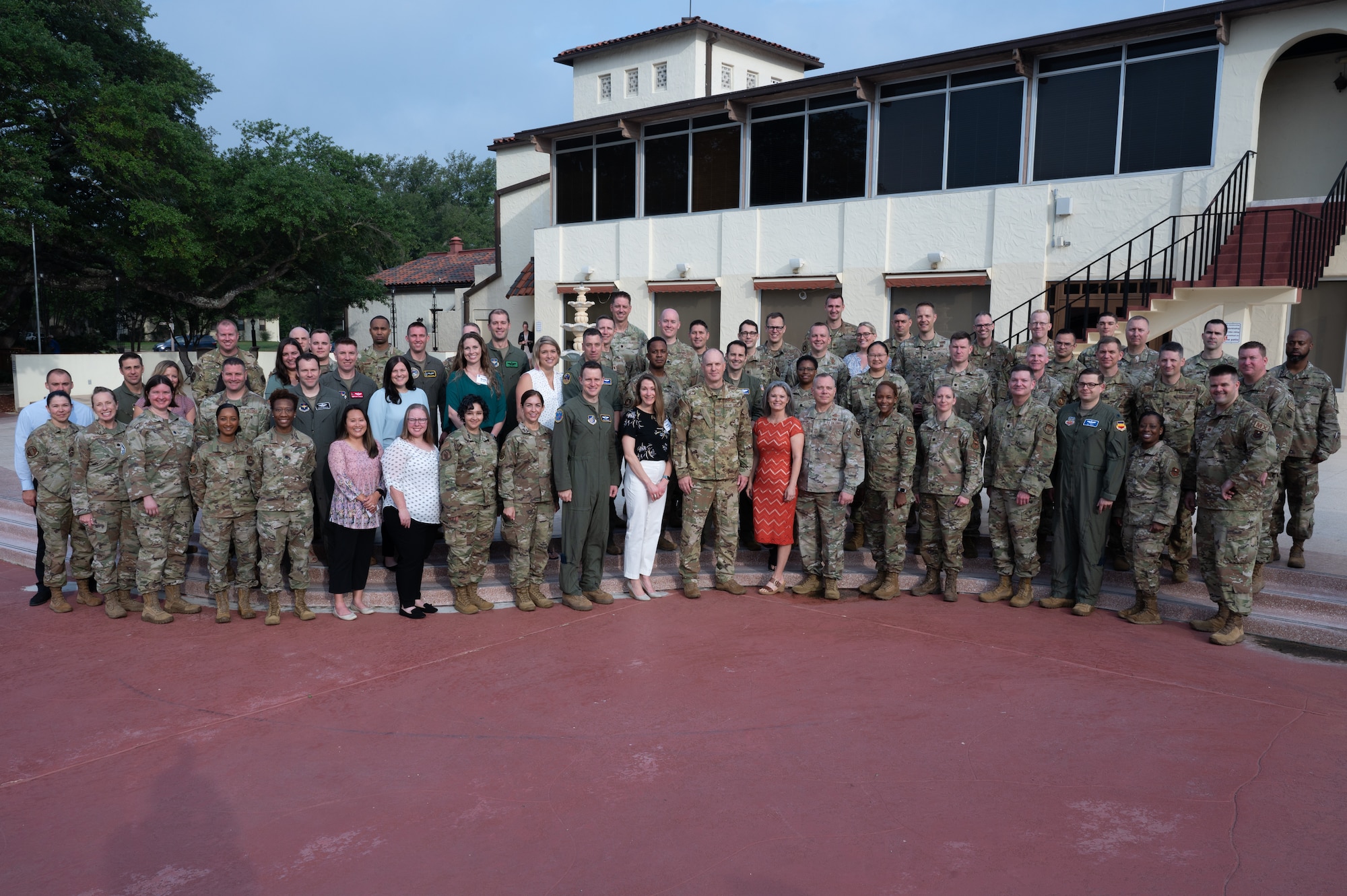Group photo of newly assigned command team and spouse standing outside of the Parr Club at Joint Base San Antonio-Randolph.