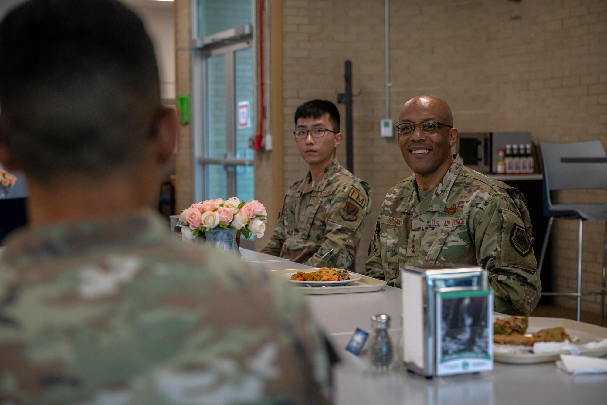 Airmen sit at a table and talk