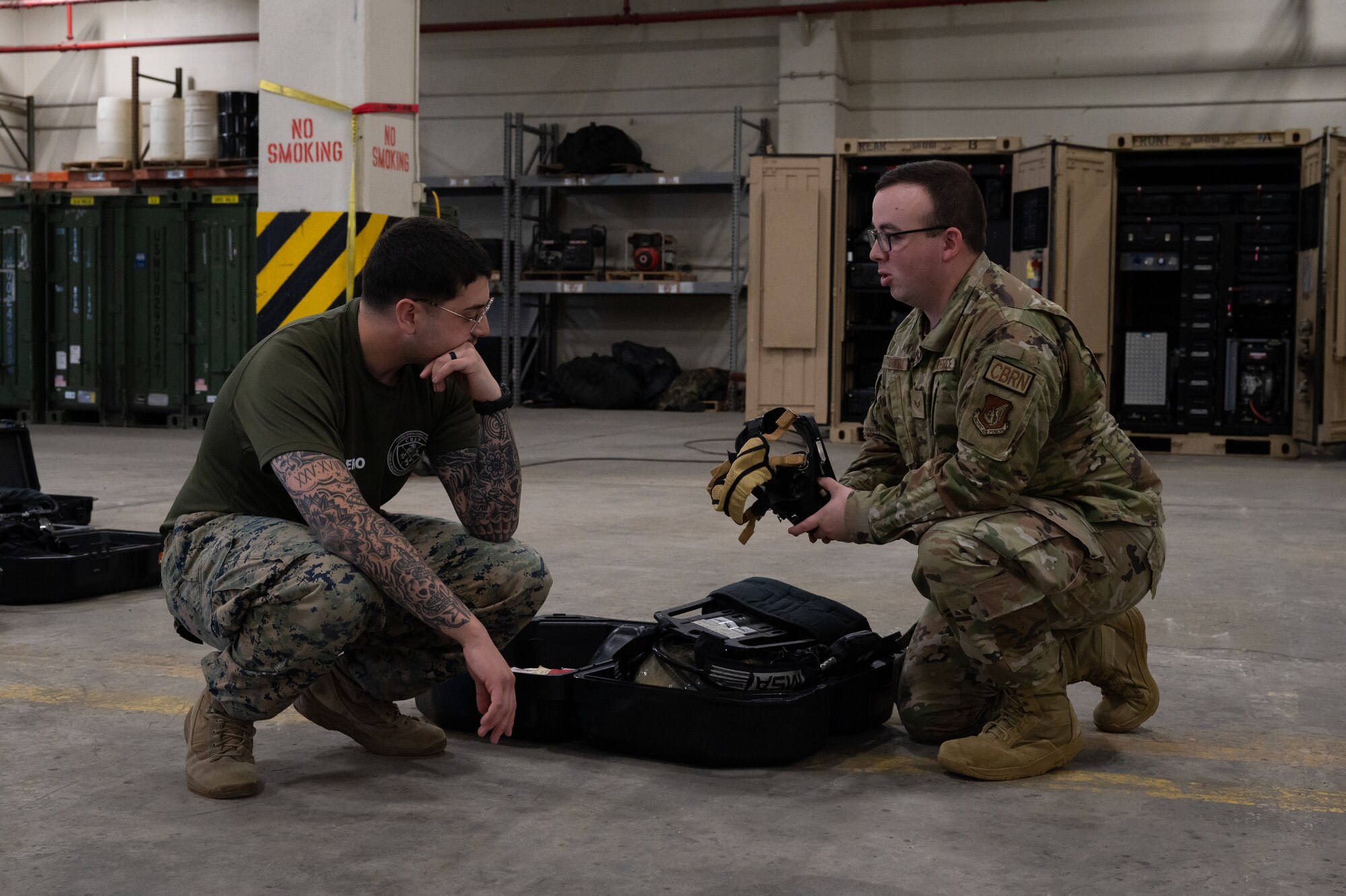 A Marine and Airman discuss CBRN equipment.