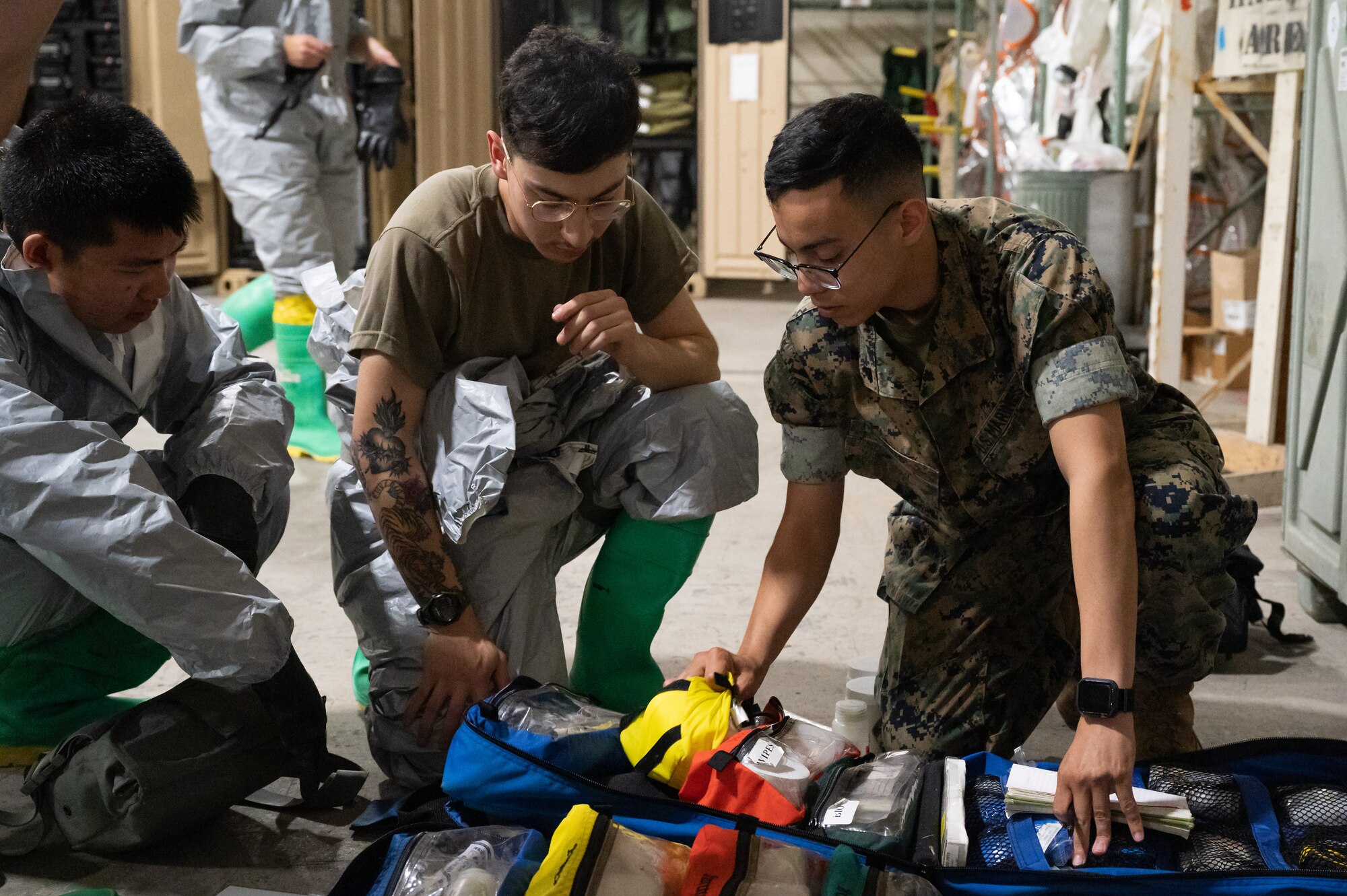 A Marine and Soldiers check CBRN equipment.