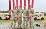 Sgt. 1st Class Talon Dumke, second from right, a combat medic assigned to the Wisconsin National Guard’s 54th Civil Support Team, with Lt. Col. Seth Kaste, right, 54th Civil Support Team commander, during the Expert Field Medical Badge ceremony May 12, 2023, at Fort McCoy, Wis. Dumke was one of eight Soldiers to complete the grueling competition, which challenged Soldiers in their technical proficiency and tactical acumen under extreme duress and scrutiny.