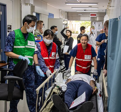 USNMRTC Yokosuka Sailors treat a simulated casualty during a large-scale, multi-day, joint-partner exercise to promote interoperability and readiness at USNH Yokosuka