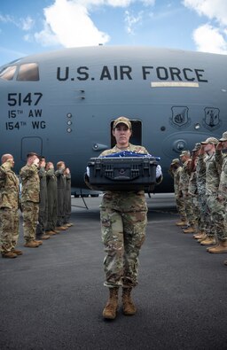U.S. Air Force Staff Sgt. Katherine Valley, a Defense POW/MIA Accounting Agency (DPAA) research analyst, carries a case during an honorable carry ceremony at Joint Base Pearl Harbor-Hickam, Hawaii, May 17, 2023. The case contains potential osseous material from a recovery site in Cambodia and received honors in route to the laboratory at DPAA where the scientific analysis will begin. (U.S. Air Force photo by Staff Sgt. Ariel Owings)