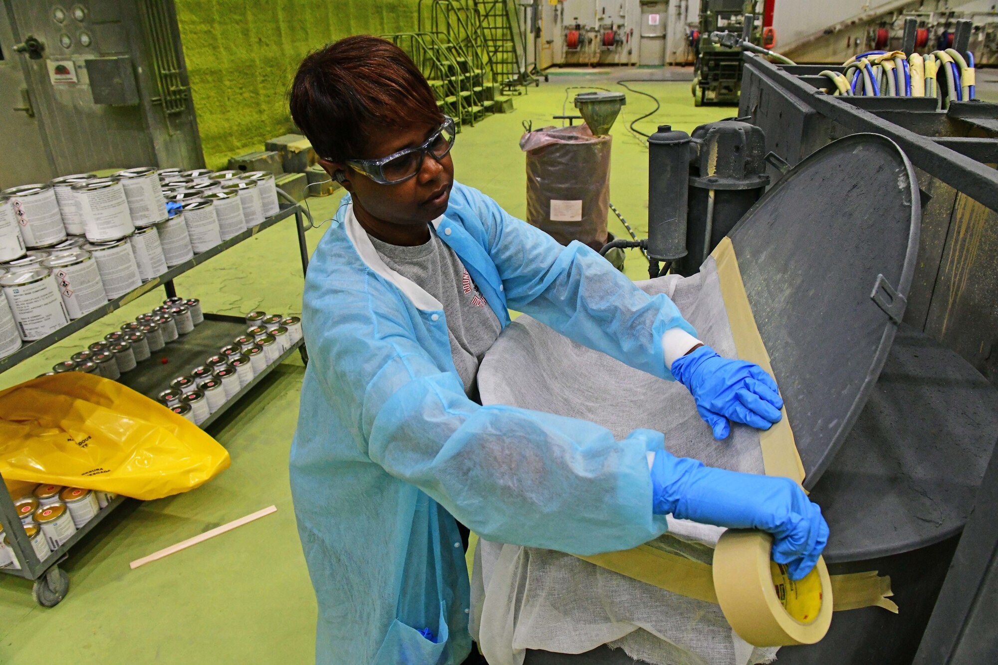 Painter taping cheese cloth to pot