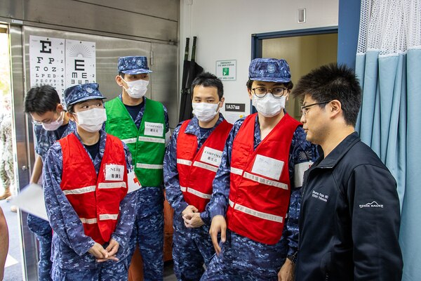 USNMRTC Yokosuka Japanese Fellow converses with JMSDF Sailors about the large-scale, multi-day, joint-partner exercise to promote interoperability and readiness at USNH Yokosuka