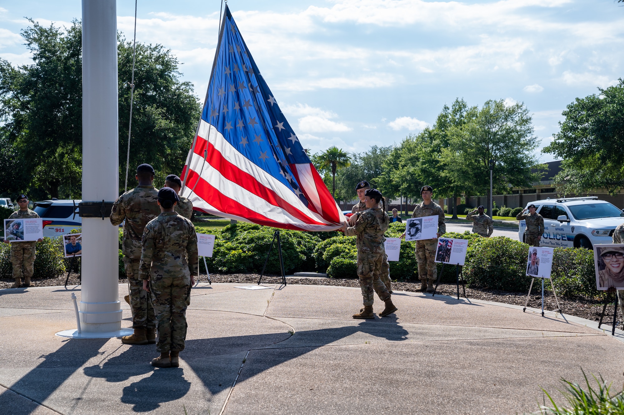 Airmen from 81st Security Forces Squadron lower the American flag during the retreat ceremony for National Police Week at Keesler Air Force Base, Mississippi, May 19, 2023.