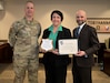 Photo of employee posing with awards given by Depot Commander and Deputy Commander