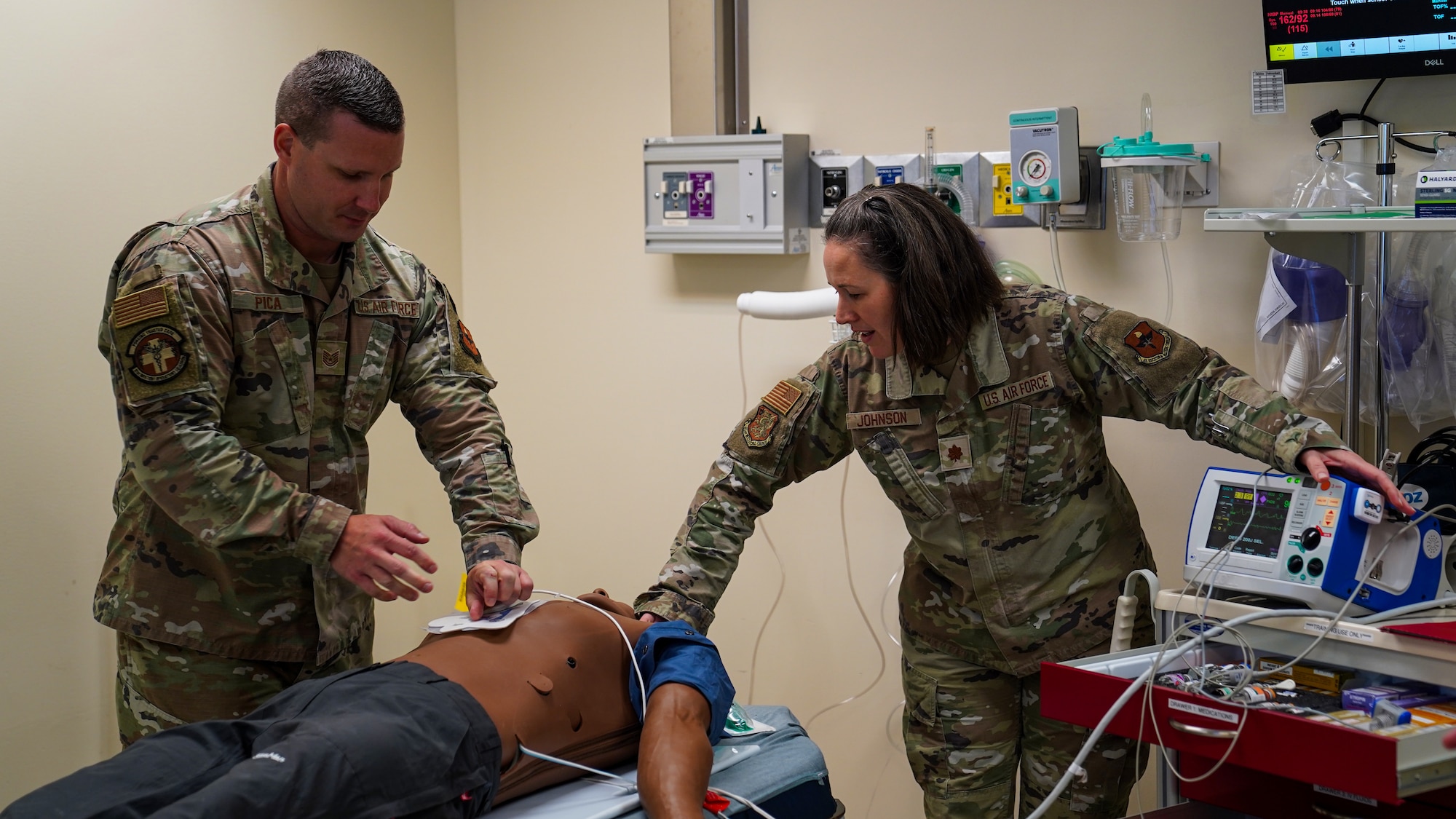 U.S. Air Force Tech. Sgt. Russel Pica, 81st Inpatient Squadron intensive care unit NCO in charge, and Maj. Racheal Johnson, 81st Operational Medicine Squadron psychiatrist, check a training mannequin for breathing sounds in the Advanced Life Support Course in the simulation lab at the Keesler Medical Center on Keesler Air Force Base, Mississippi, May 17, 2023.
