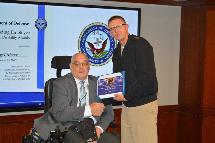 Mr. George Moore (left), program analyst for Strategic Systems Programs (SSP) poses for a photo after he is given the Secretary of Defense 2022 Outstanding Civilian with a Disability Award by Vice Adm. Johnny R. Wolfe, director of SSP (right). The award honors the accomplishments of individuals who have made significant contributions to their command’s mission and have, at the same time, consistently demonstrated the core values of their command. (Photo by Joseph Ross/Released)