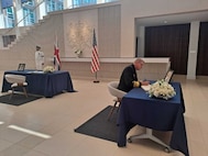 Vice Adm. Johnny Wolfe, Jr., Director, Strategic Systems Programs (SSP) signs the official condolence book for Her Late Majesty Queen Elizabeth II at the British Embassy. Wolfe’s visit underscored the importance of the special relationship between the United States and the United Kingdom, which includes the Polaris Sales Agreement, an international agreement established between the U.S. and the UK in April 1963. The agreement provides for the sale to the UK of the Trident Strategic Weapon System. (British Embassy Photo/Released).