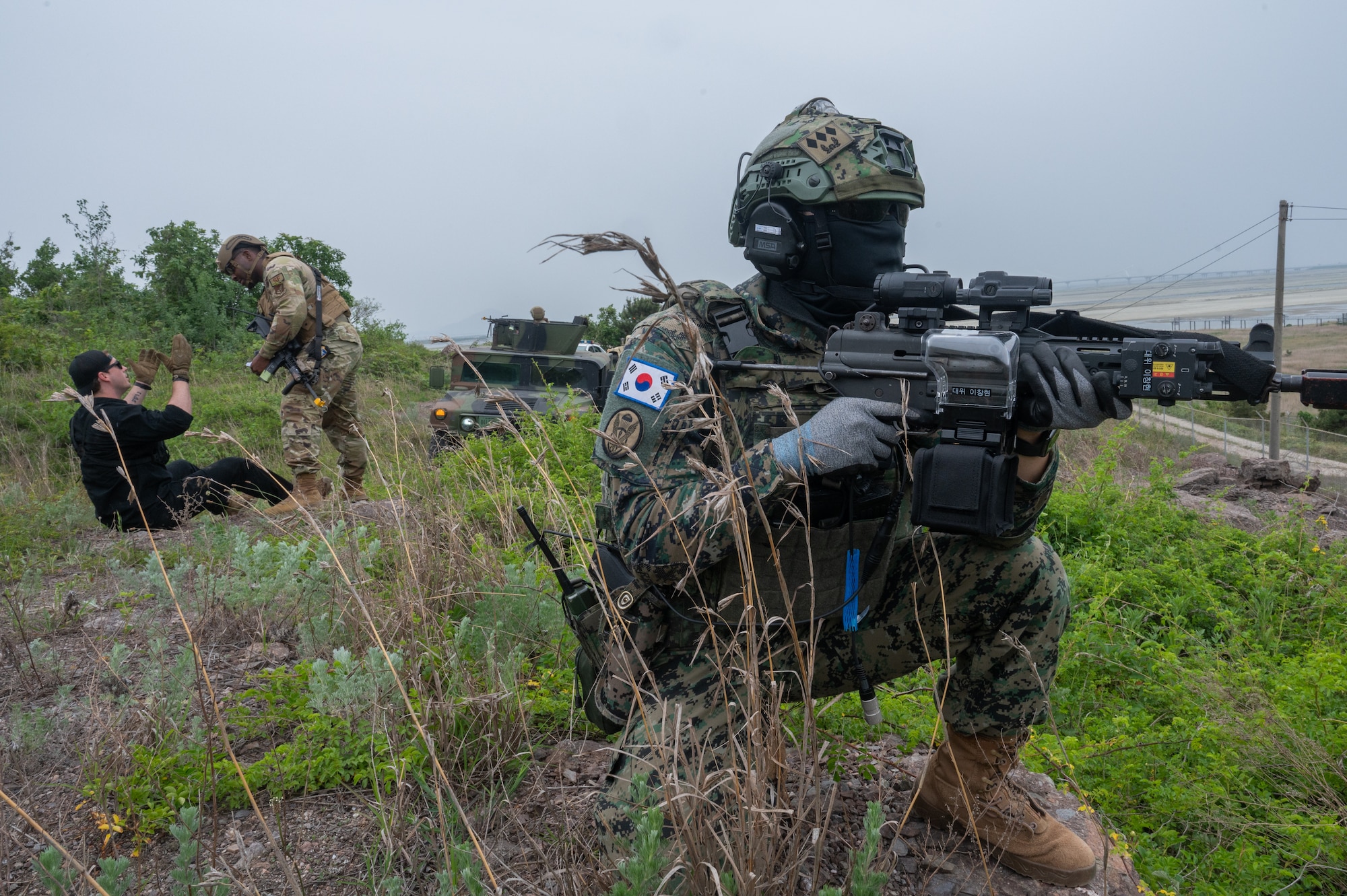 A Republic of Korea Army soldier remains vigilant while U.S. Air Force Tech. Sgt. Keshawn Reedus, 8th Security Forces Squadron Defender, details a simulated trespasser during a training event at Kunsan Air Base