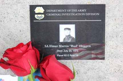 A remembrance placard and red roses are placed near the engraved name of Army CID Special Agent Elmer "Bud" Heggen at the National Law Enforcement Officer Memorial in Washington D.C.