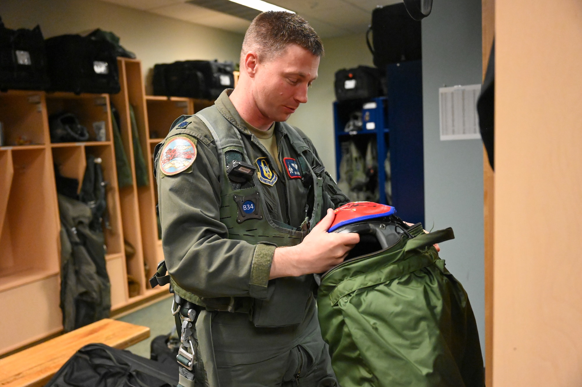Lt. Col Ryan Enlow prepares flight gear prior to flight.