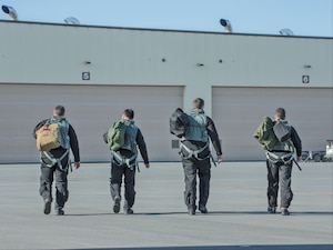 Four F-22 Raptor Pilots from the 302d Fighter Squadron step to their aircraft and prepare for flight.