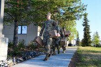 From the front, Senior Airman Jakob Stokes, Senior Airman Sean Lake, and Tech Sgt. Vincent McKiernan, 168th Wing, Alaska Air National Guard, carry meals, ready to eat to a government vehicle in preparation to travel to Circle, Alaska, May 23, 2023, to support flood-recovery operations. Four Guardsmen and one member of the Alaska State Defense Force will assist with cleanup and flood recovery efforts at the request of the Alaska State Emergency Operations Center. (Alaska Air National Guard photo by Senior Master Sgt. Julie Avey)