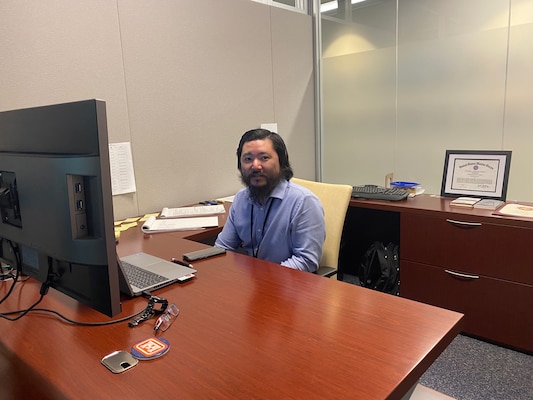 Ken Kajihiro working at his desk for the Transatlantic Middle East District.