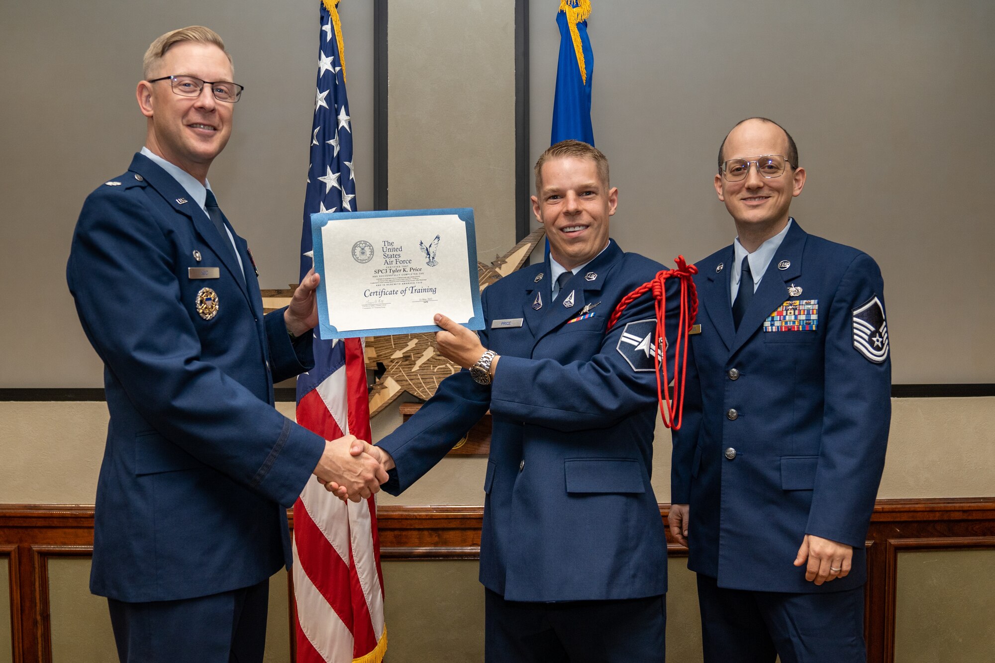 U.S. Space Force Specialist 3 Tyler Price, Cyber Warfare student, receives his certificate of training during a graduation ceremony at Keesler Air Force Base, Mississippi, May 22, 2023.