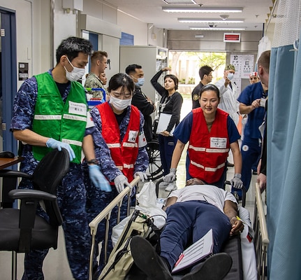 USNMRTC Yokosuka Sailors treat a simulated casualty during a large-scale, multi-day, joint-partner exercise to promote interoperability and readiness at USNH Yokosuka