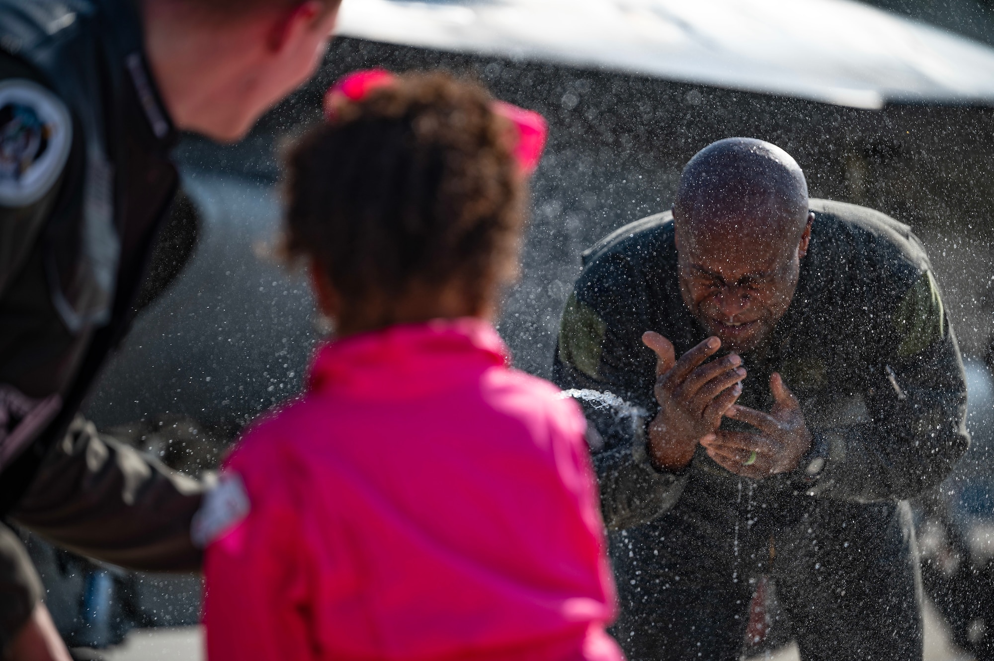 Amelia Jeffress, center, daughter of Col. Henry R. Jeffress, III, right, 8th Fighter Wing commander, sprays water at her father in celebration of his final F-16 flight at Osan Air Base, Republic of Korea, May 17, 2023. It is tradition to hose down the pilot as they step out of the aircraft upon completion of their final flight.   (U.S. Air Force photo by Senior Airman Karla Parra)